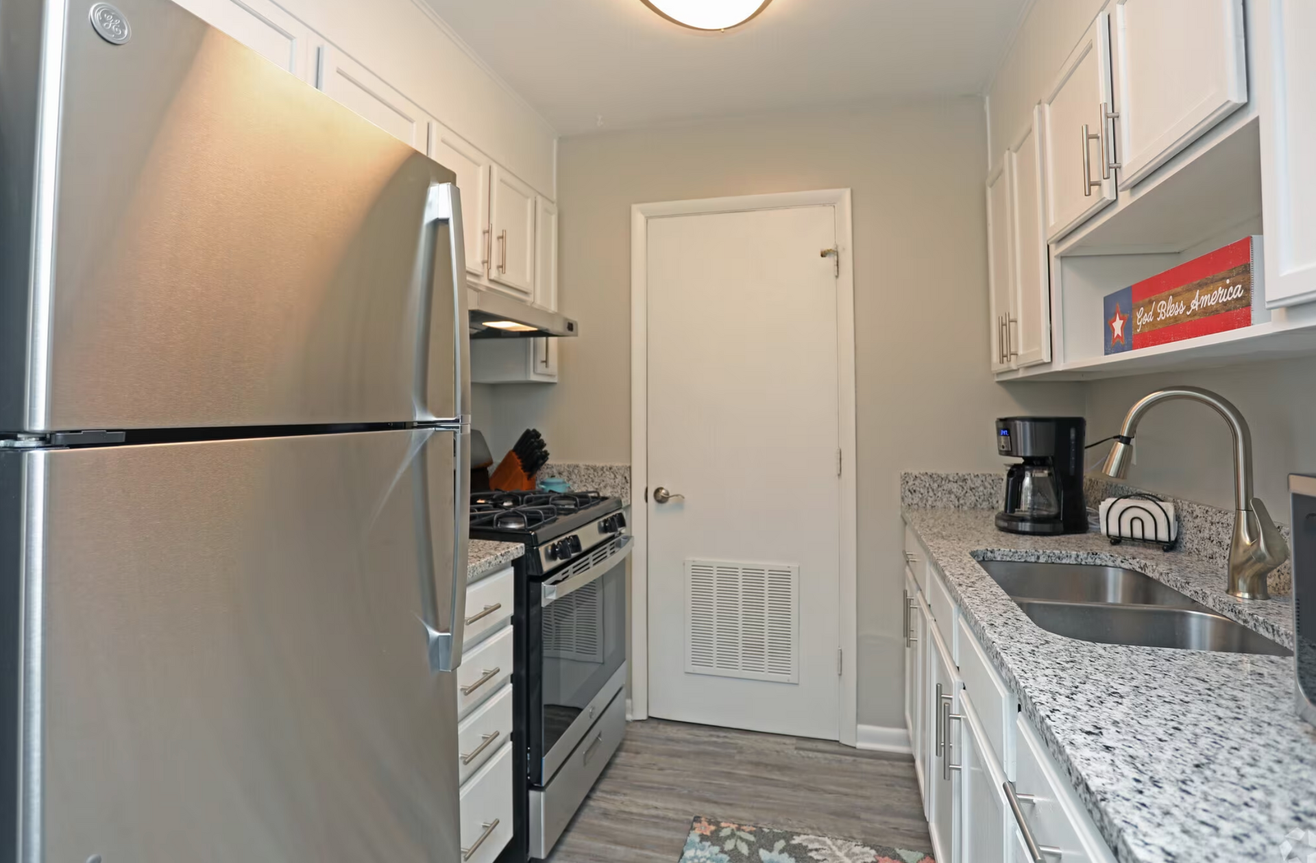 A kitchen with stainless steel appliances and granite counter tops.