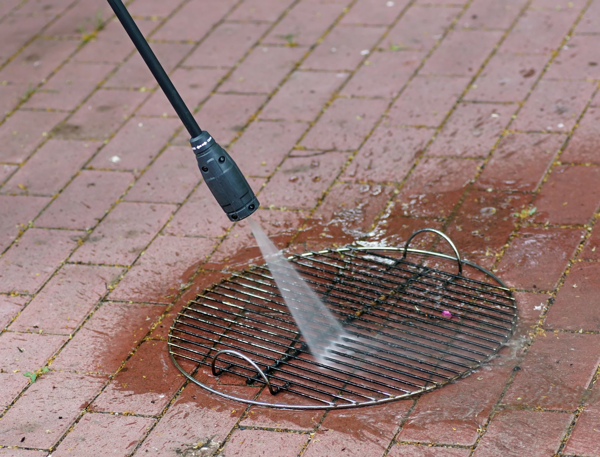 A grill is being cleaned with a high pressure washer