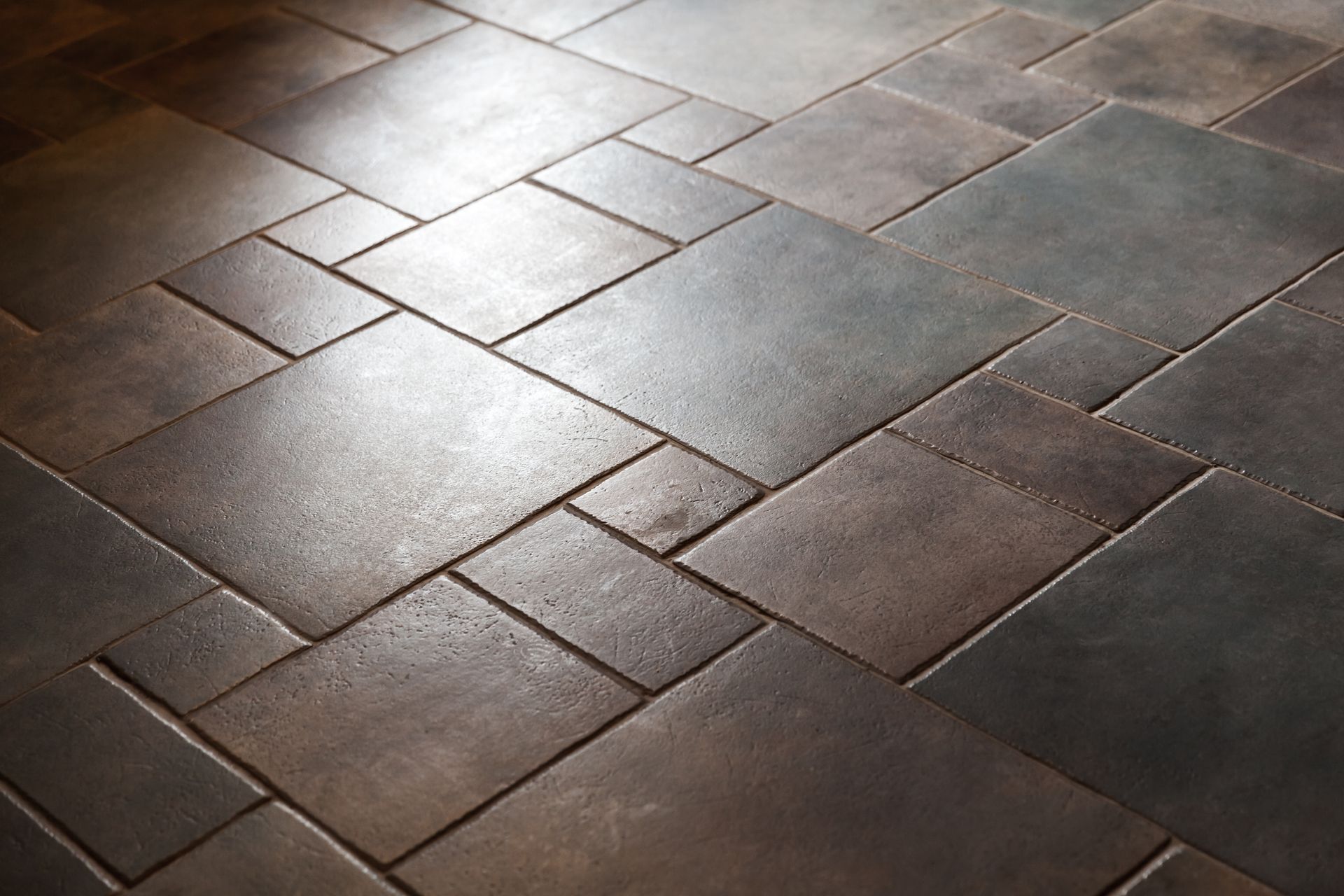 A close up of a tiled floor with a herringbone pattern