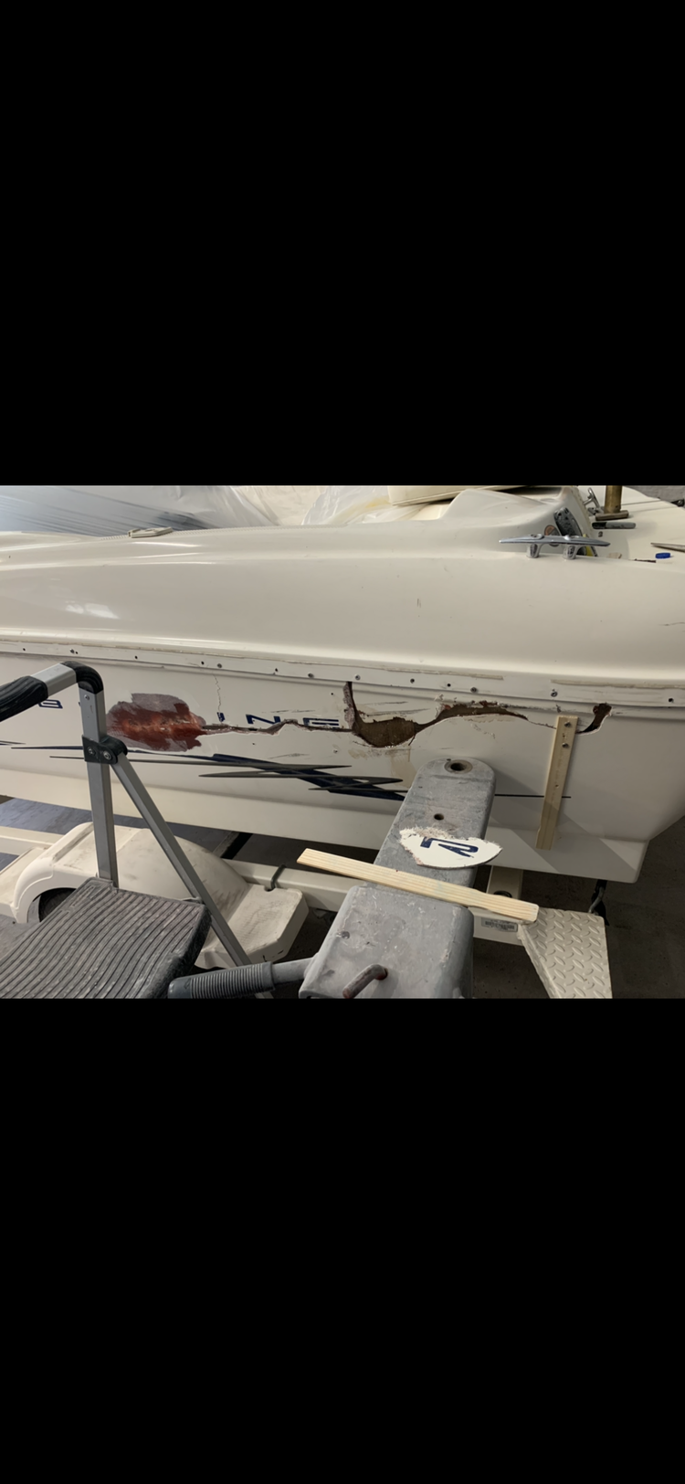 A boat is sitting on top of a table in a garage.