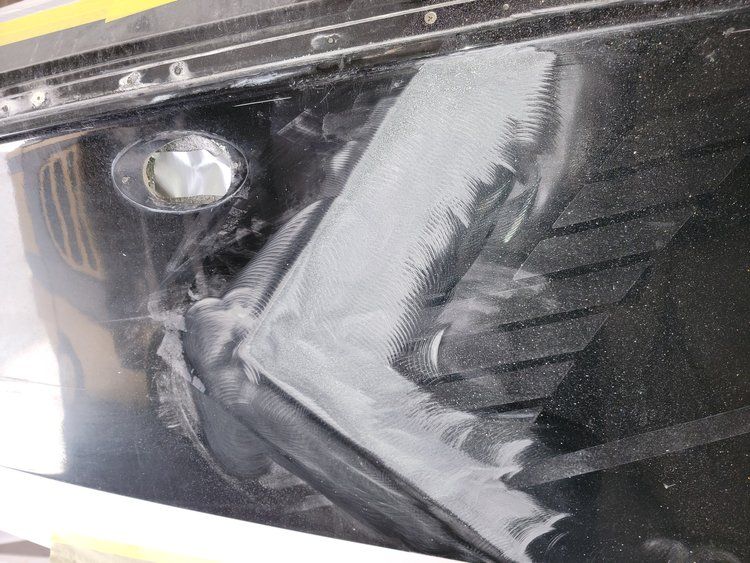 A close up of a car headlight on a black car.