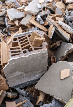 Pile of broken concrete and cinder blocks rubble with scattered debris