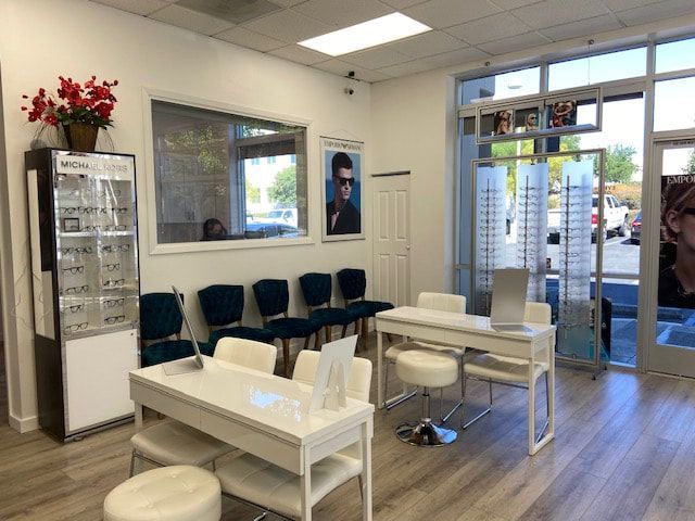 A waiting room with tables and chairs in an optical shop.