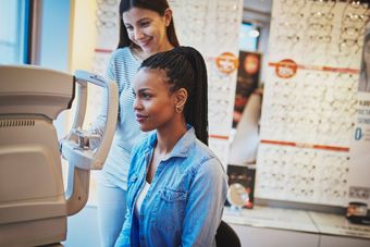 A woman is getting her eyes checked by an ophthalmologist in an optical shop.