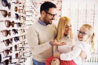 A family is trying on glasses in an optical shop.