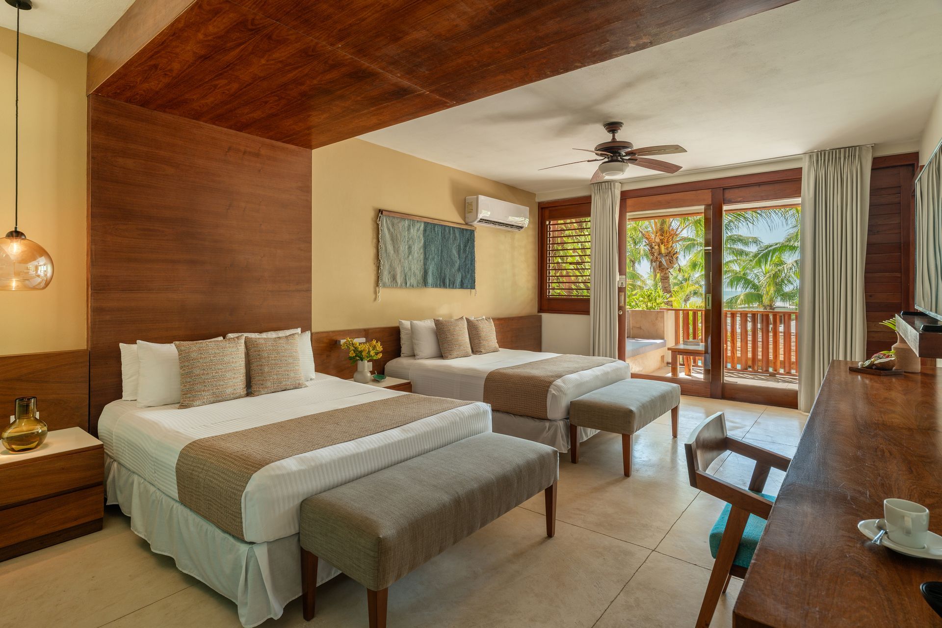 Hotel room with two beds, wooden accents, and balcony access.