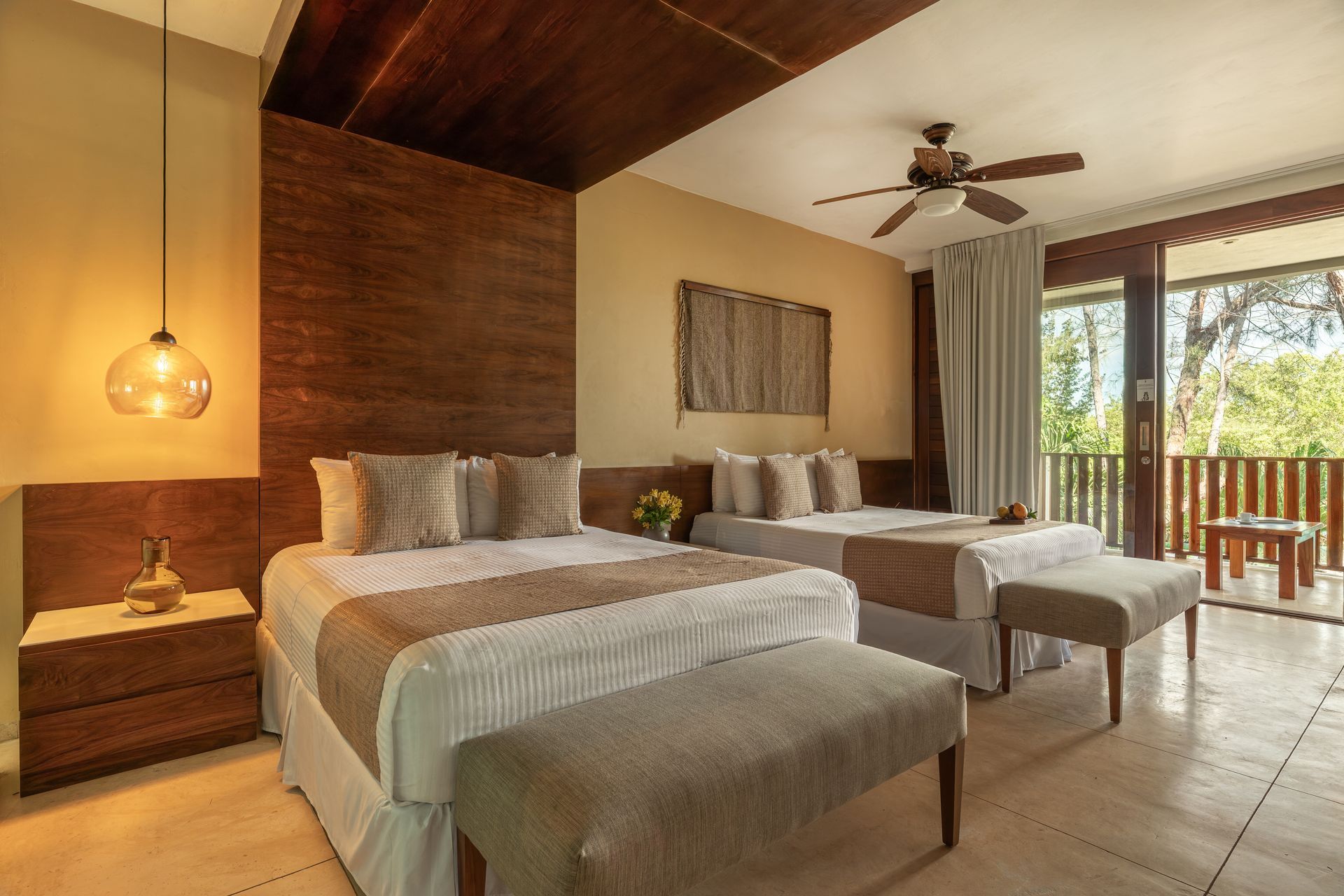 Two beds in a hotel room with a balcony view.