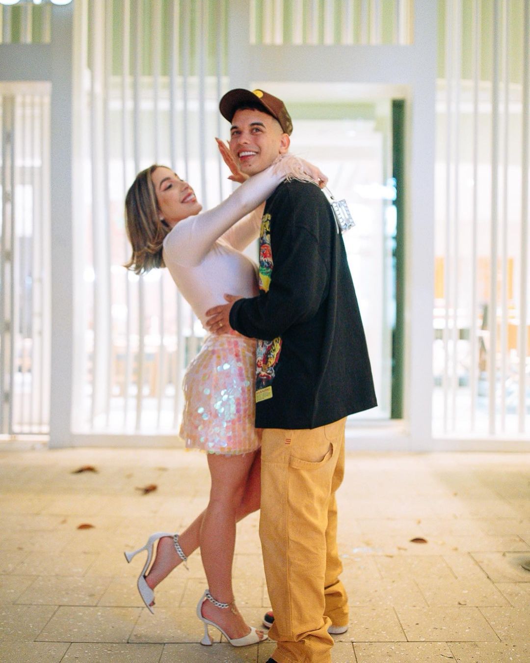 A man is holding a woman in his arms in front of a building.