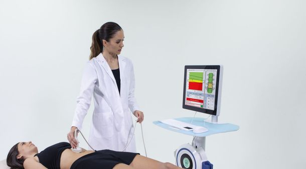 A doctor is examining a woman 's stomach with a machine.