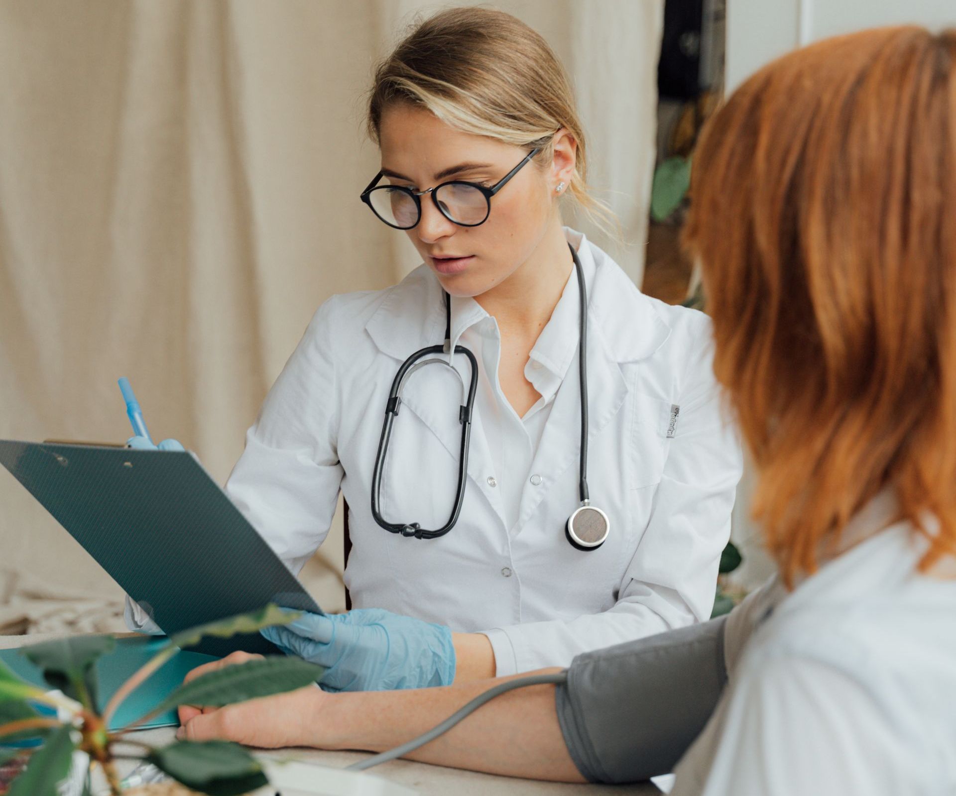 a doctor looks at a chart while talking to a patient