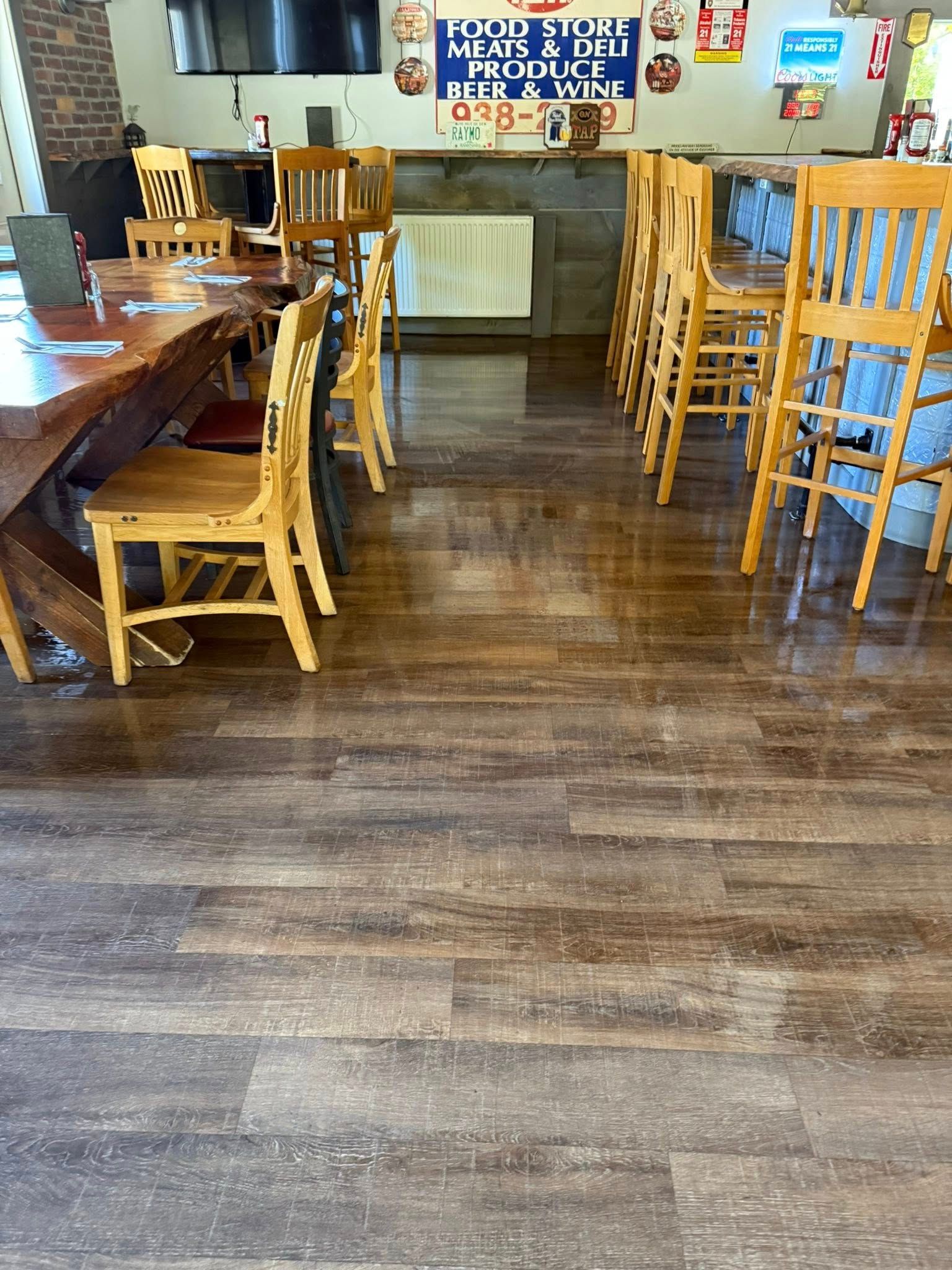 A person stands barefoot, leaning against a grey electric vehicle charging at a home garage.