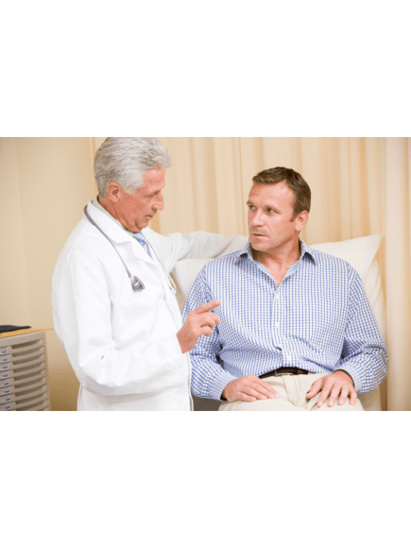 Médico conversando com um paciente sentado em uma cama em uma sala de exames médicos.