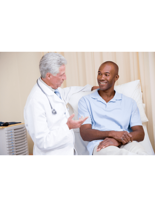 Médico conversando com um paciente em uma sala de exames.