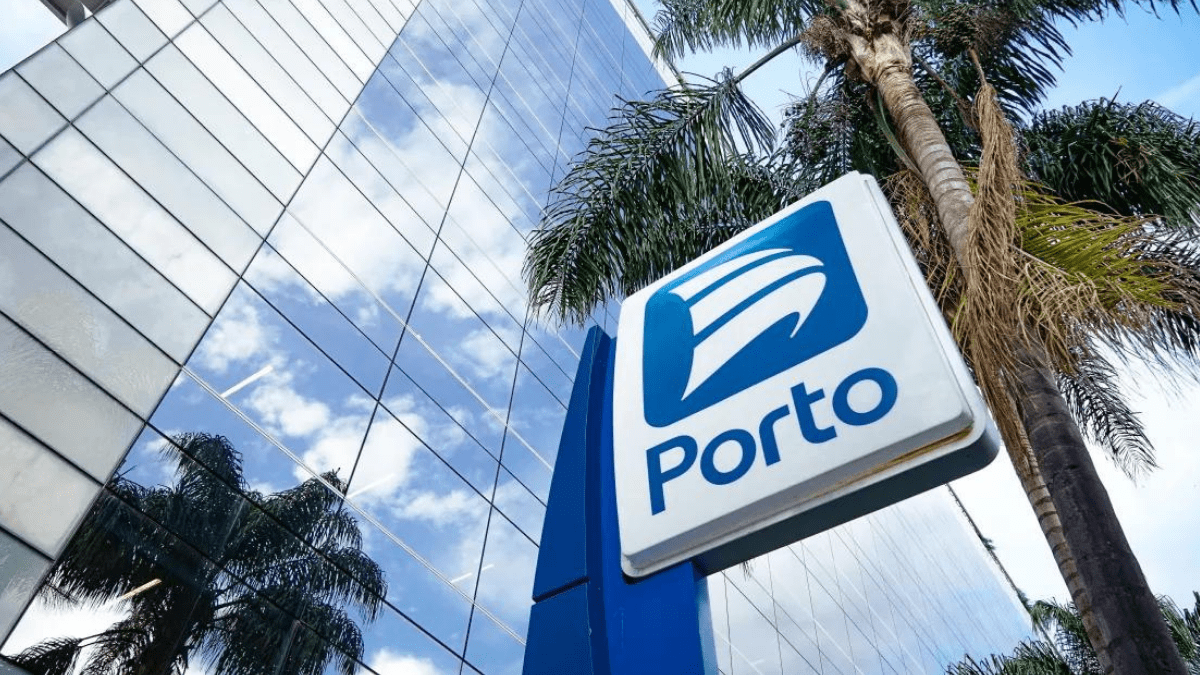 Placa do Porto com logotipo em suporte azul, refletindo a arquitetura moderna e a palmeira.