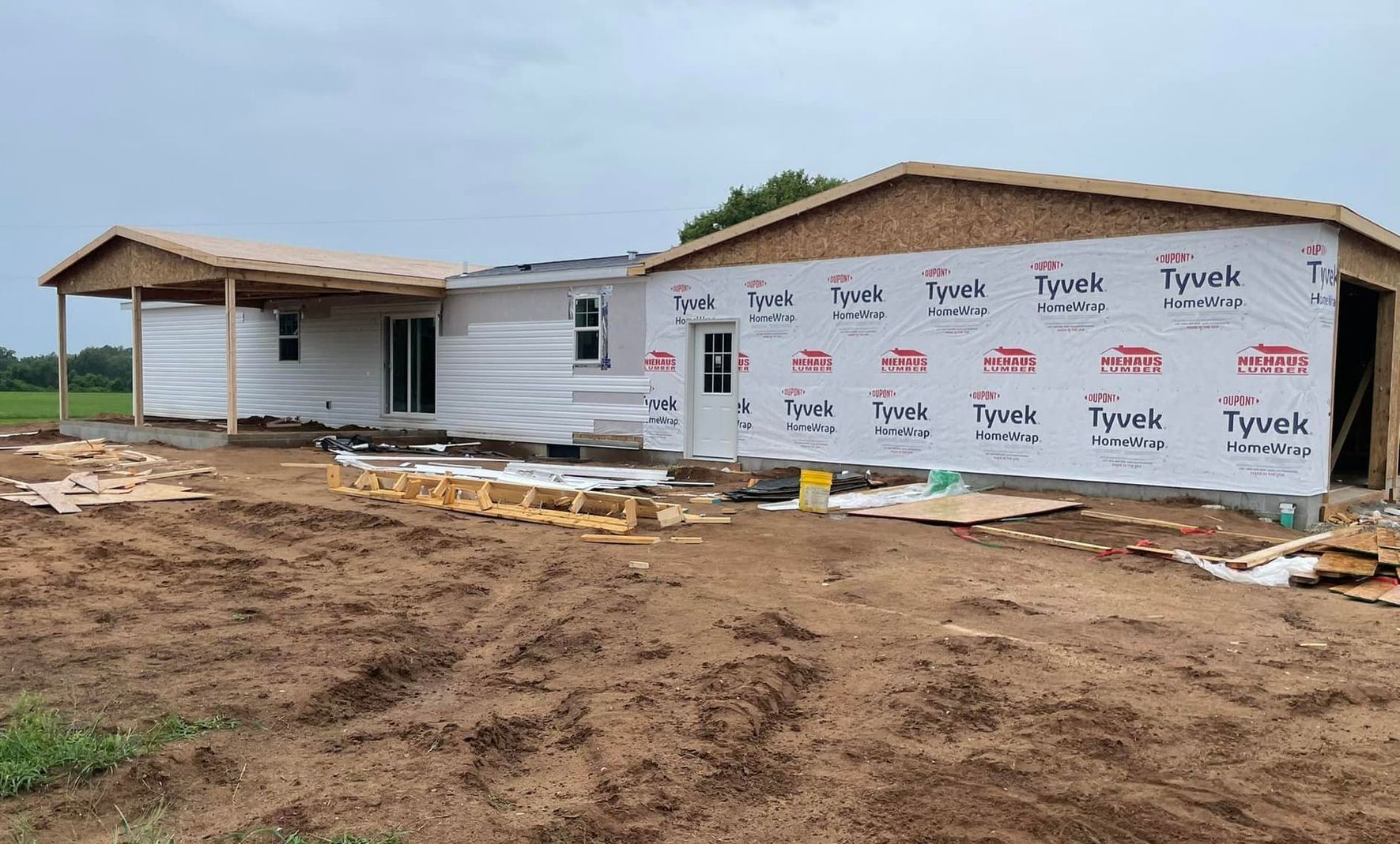 A house is being built in the middle of a dirt field.