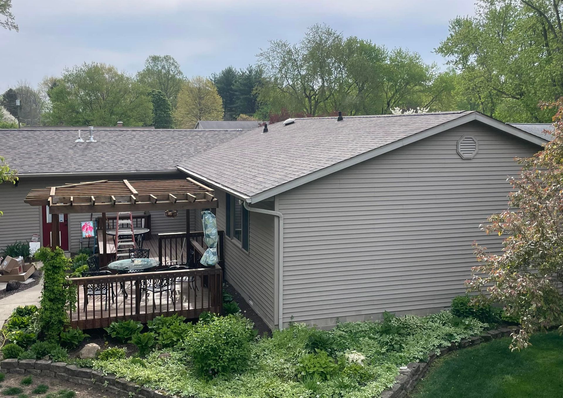 A house with a deck and a pergola in the backyard