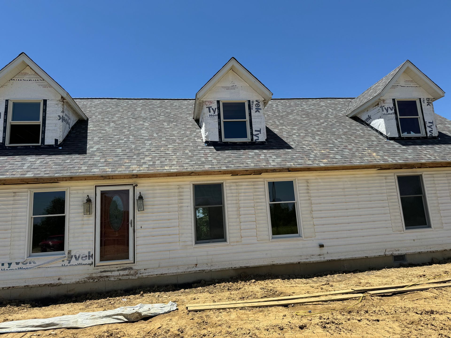A white house with a gray roof and a lot of windows