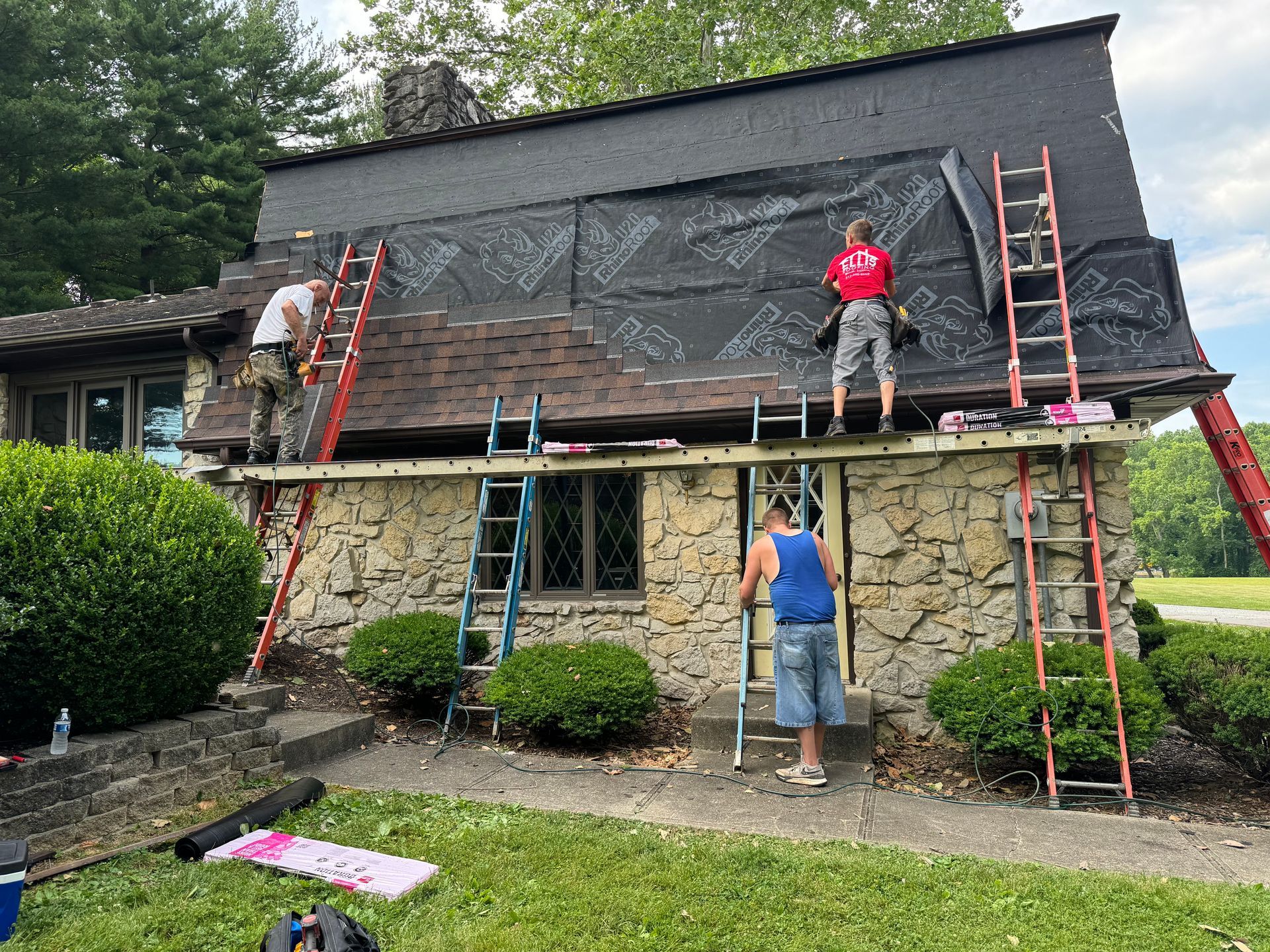 A group of men are working on the roof of a house.