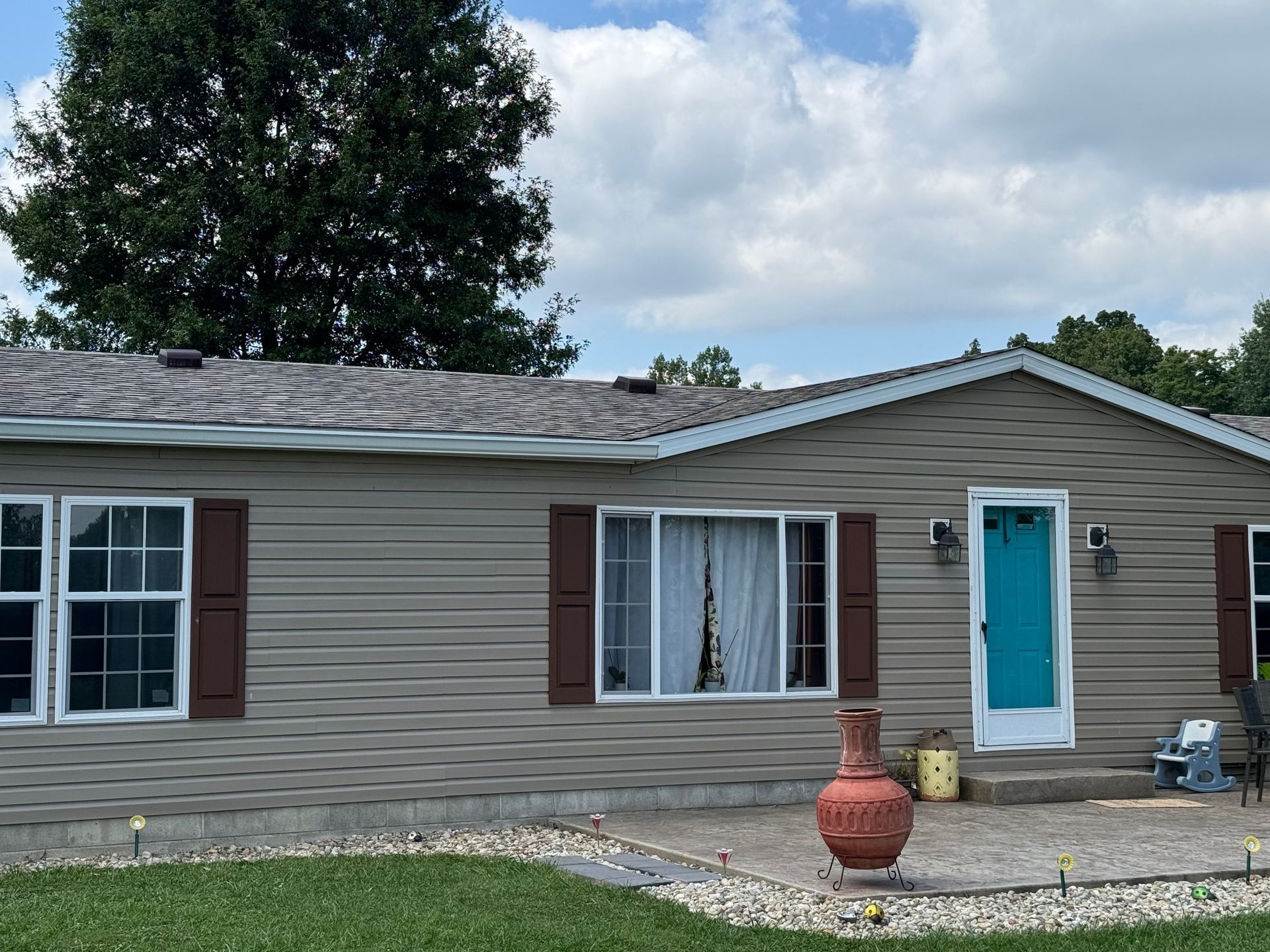 A mobile home with a blue door and brown shutters
