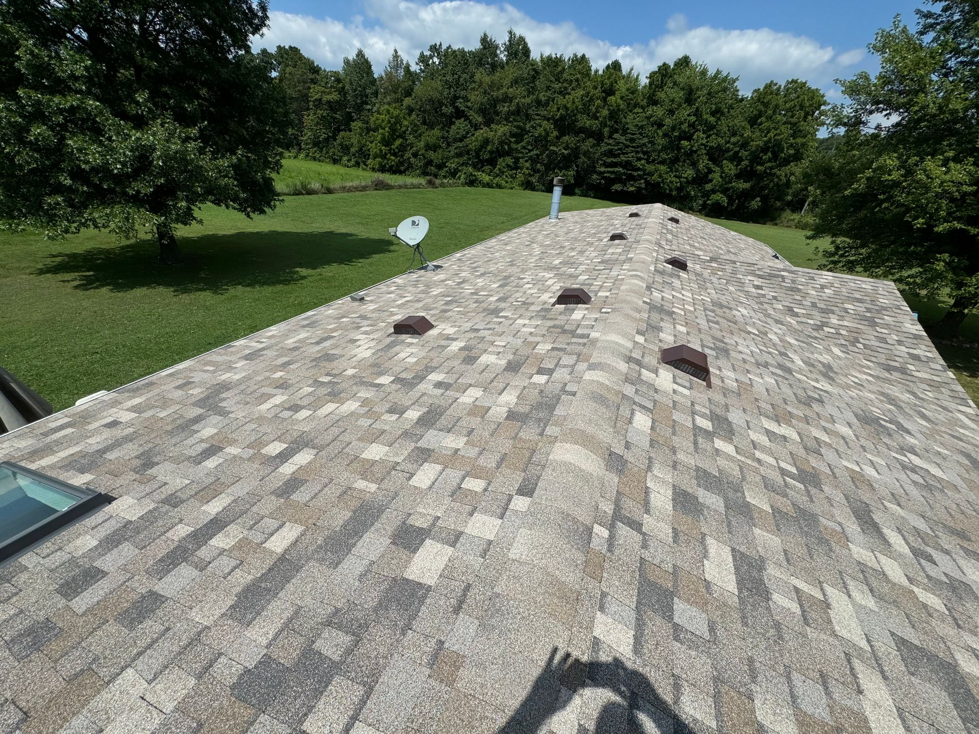 A roof with a skylight and a satellite dish on it