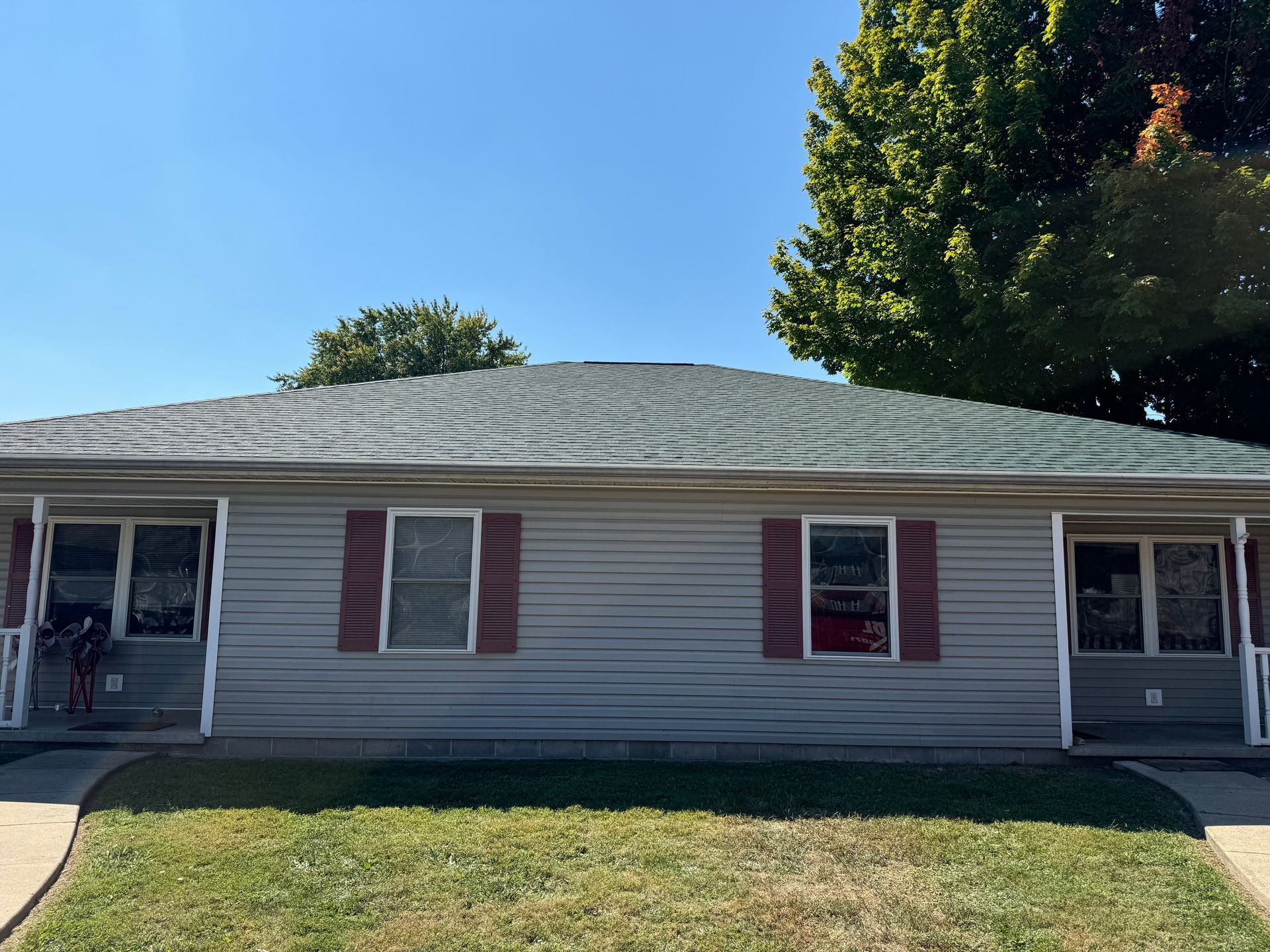 A house with a green roof and red shutters