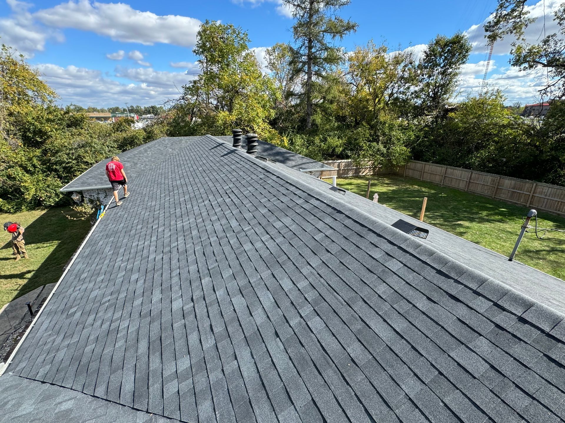 A man is working on the roof of a house.