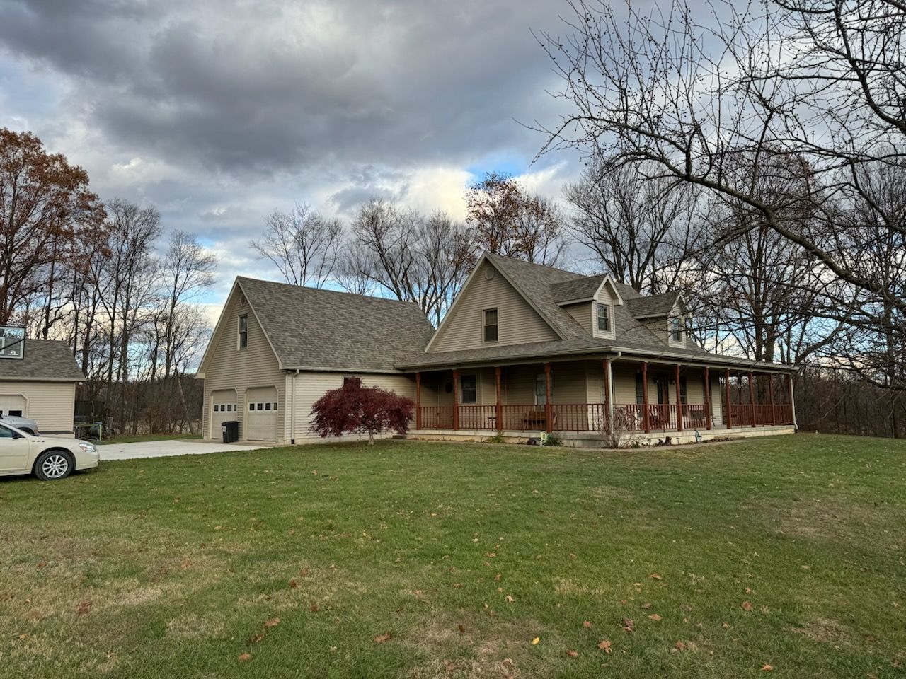 A house with a porch and a car parked in front of it