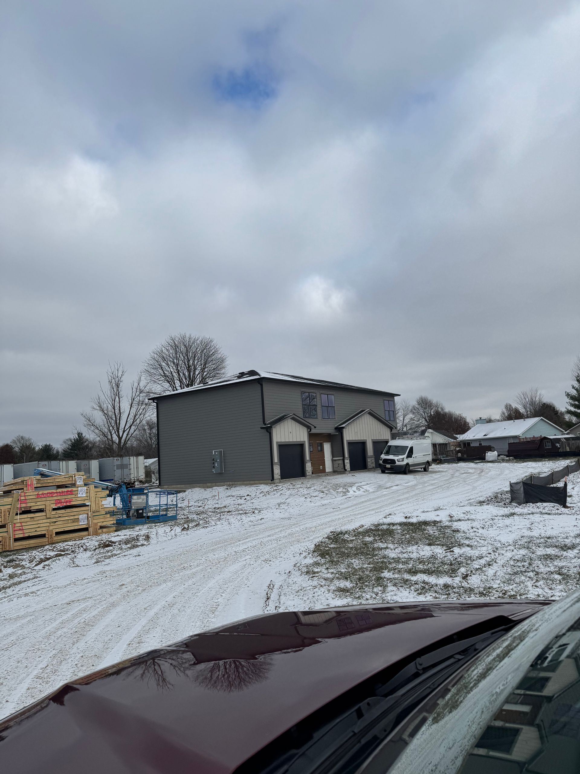 A car is parked in front of a building in the snow.