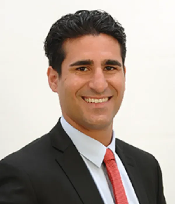 A man in a suit and tie is smiling for the camera