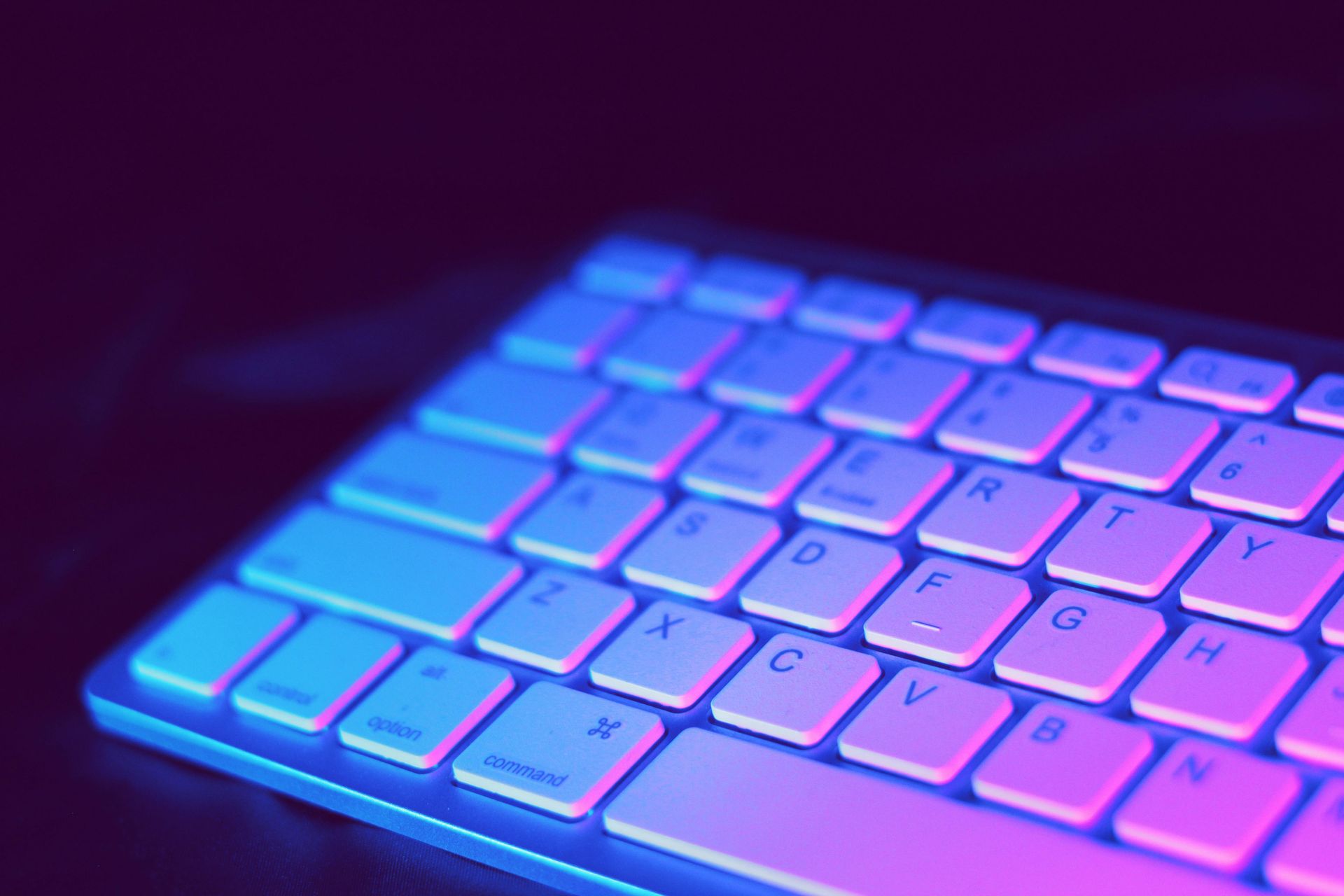 A close up of a keyboard with blue and purple lights on it