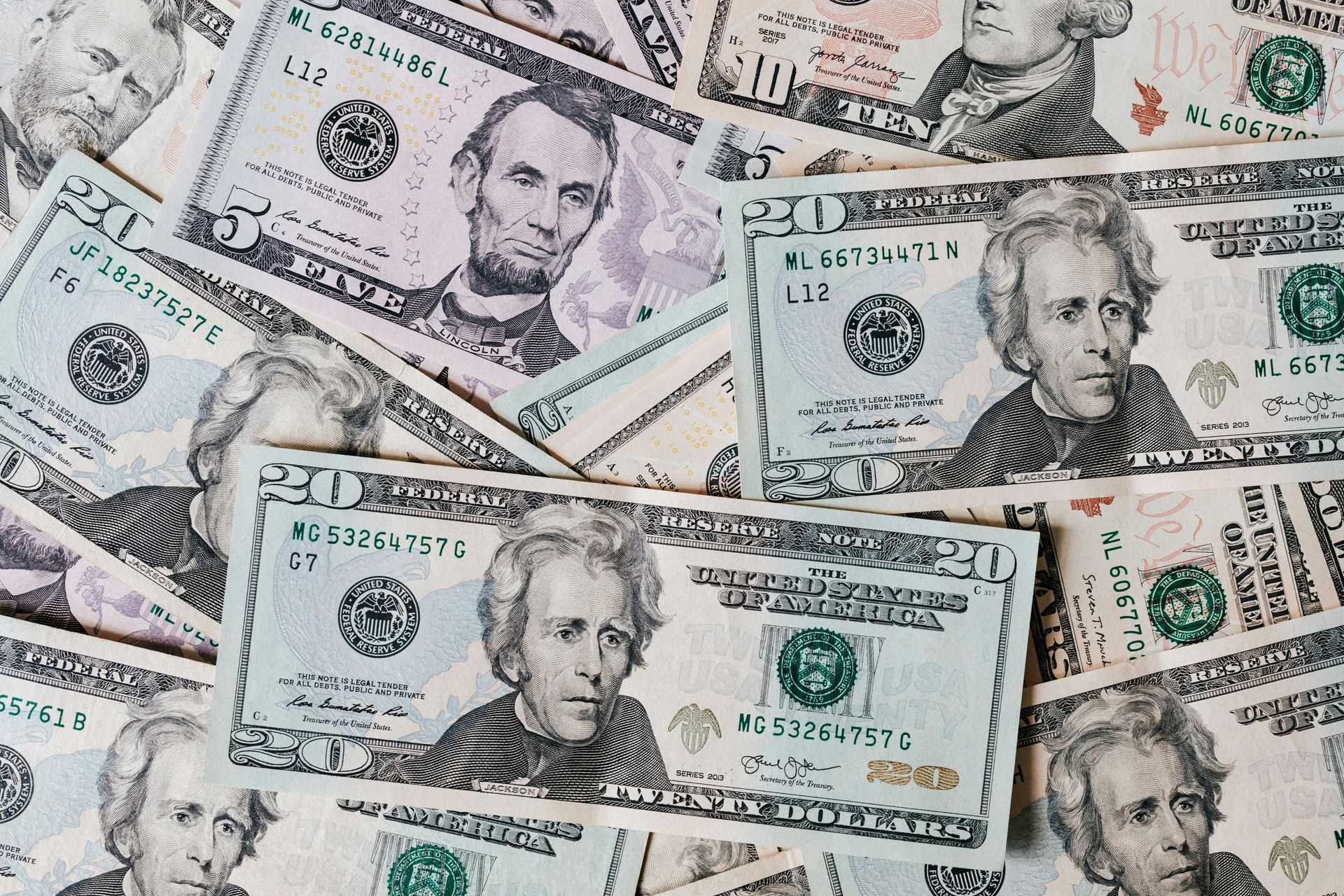 Pile of US dollar bills, including $5 and $20 denominations.