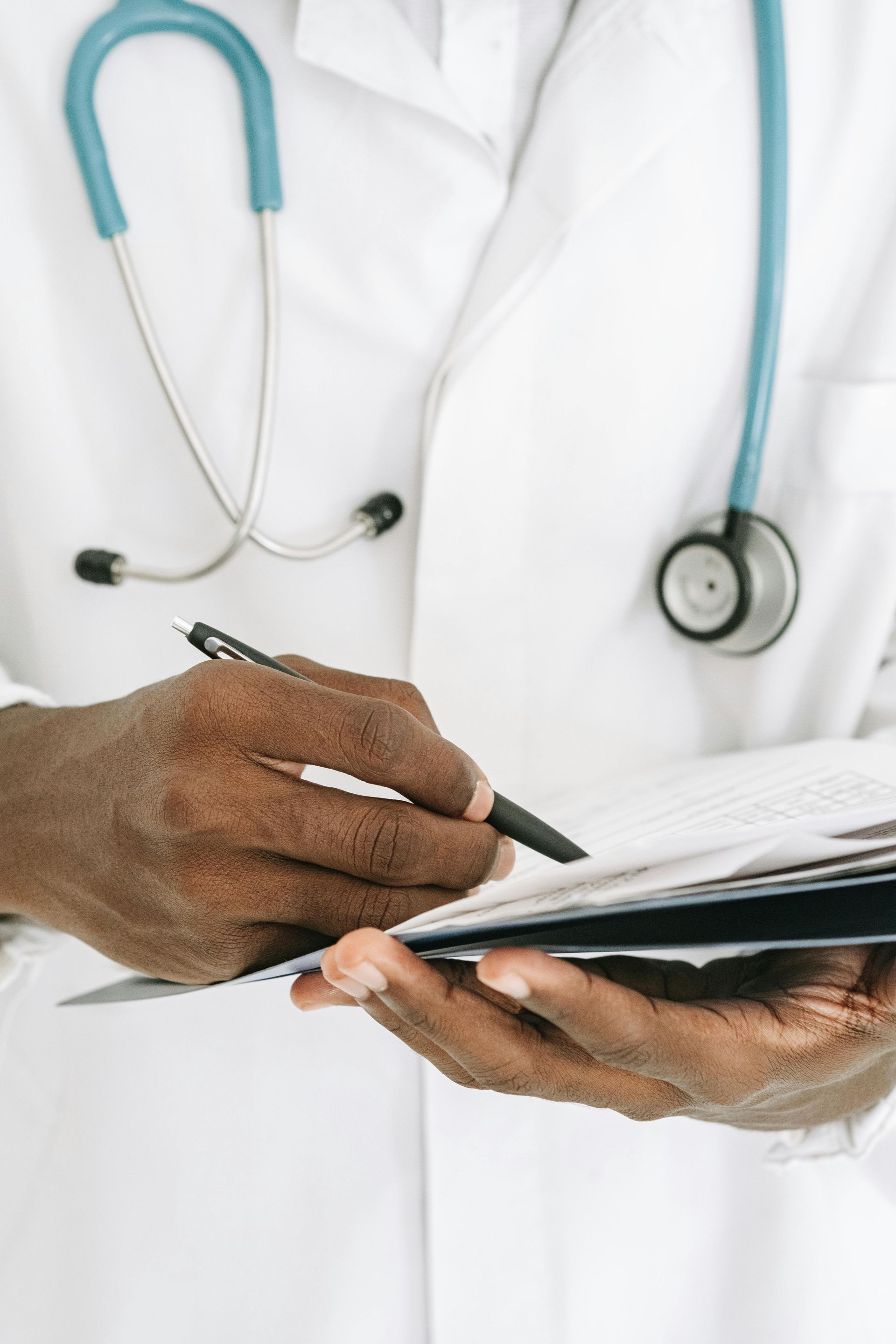 A doctor looking over a patient's medical chart and making notations.