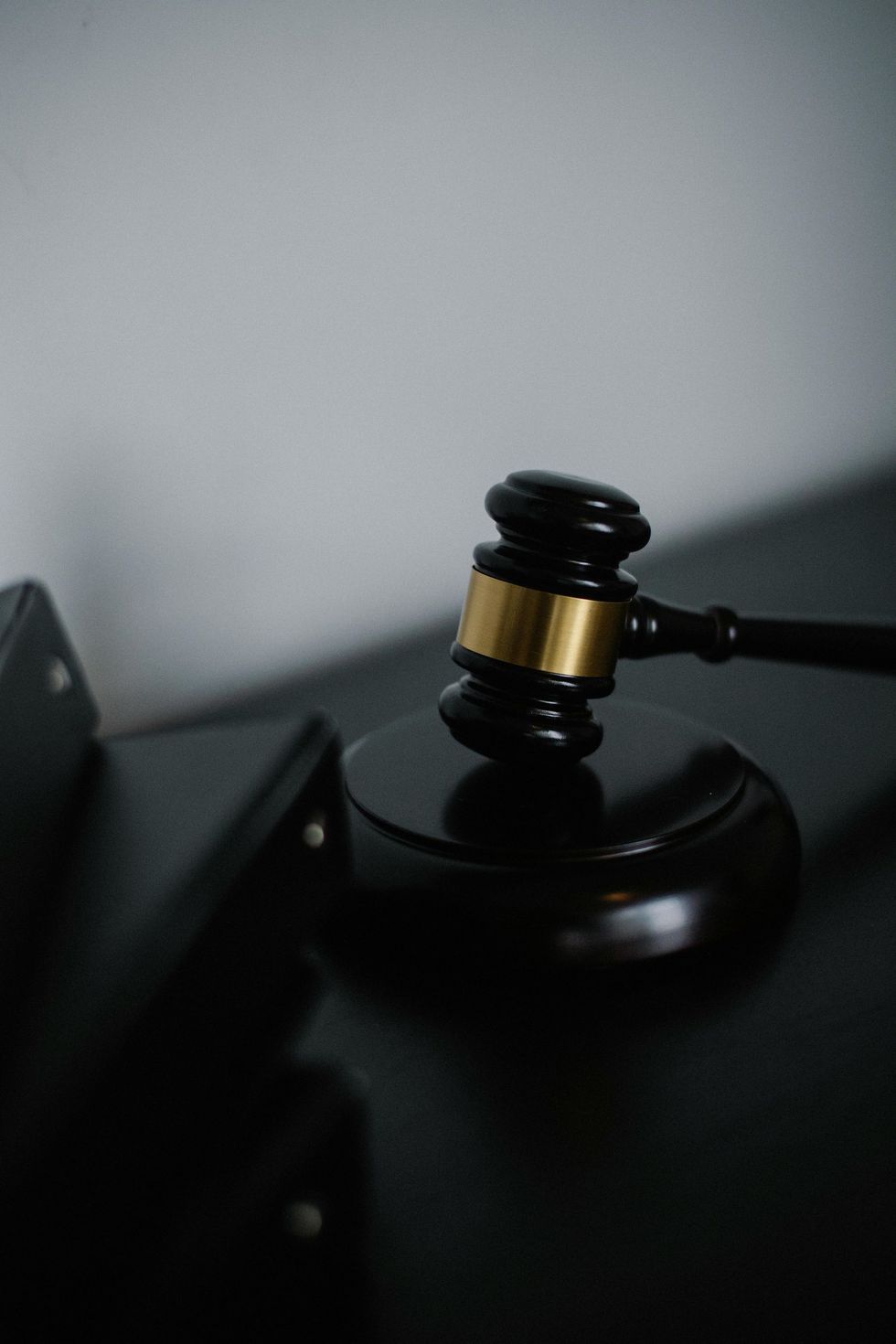 A judge 's gavel is sitting on top of a black table.