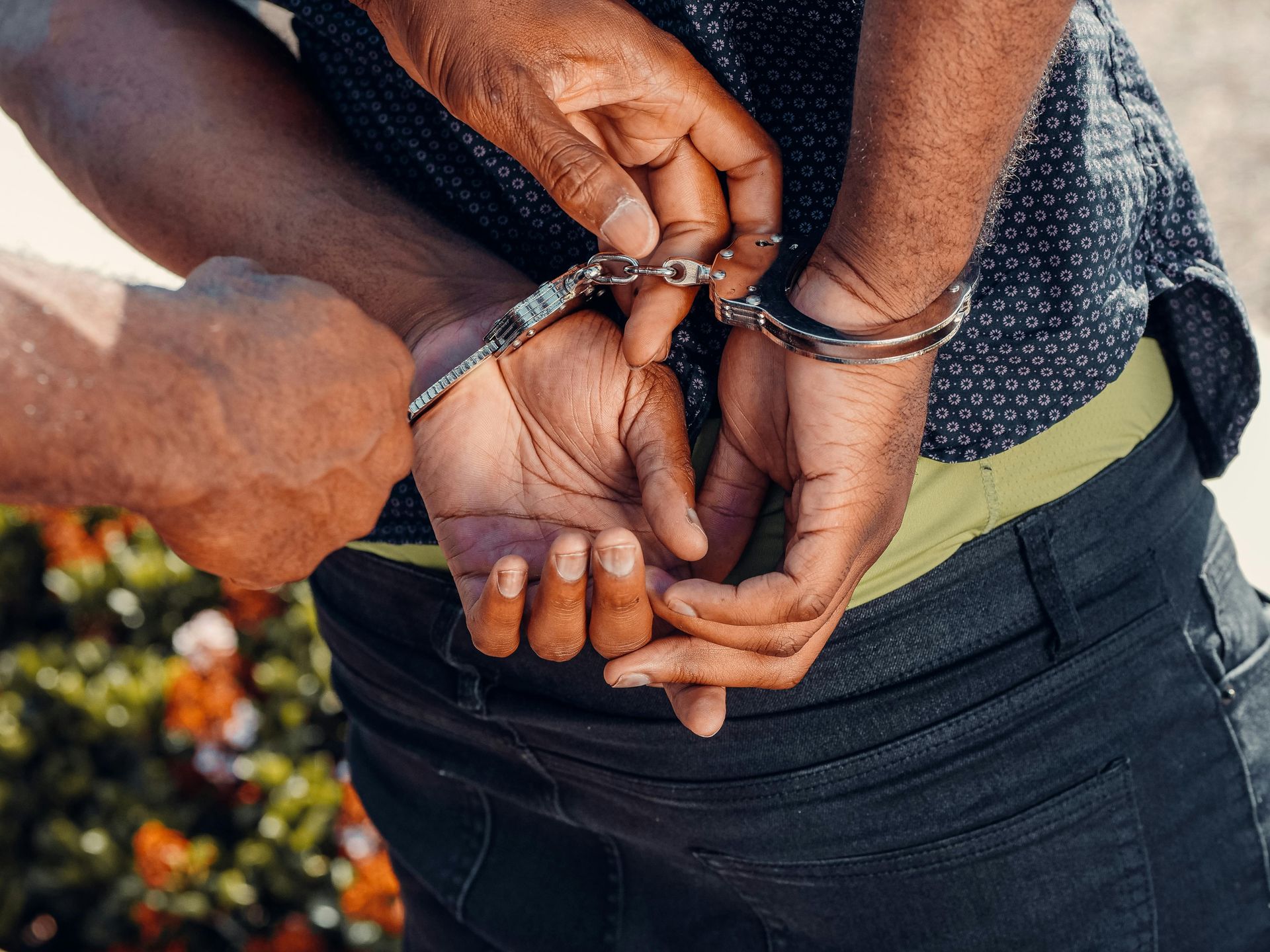 A picture of a police officer putting a criminal in handcuffs.