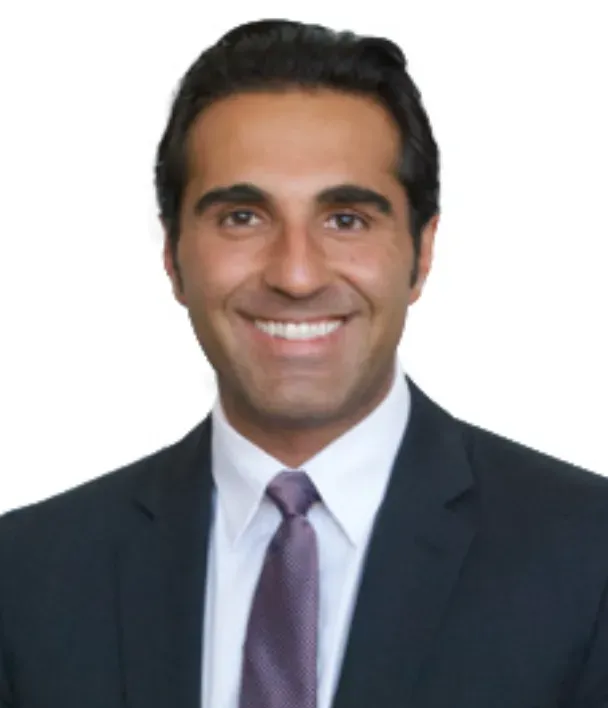 A man in a suit and tie is smiling for the camera