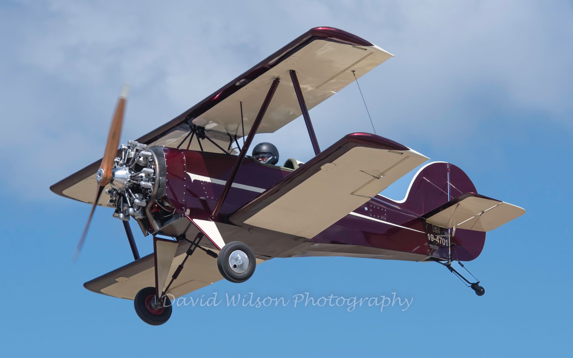a small plane is flying through a blue sky .