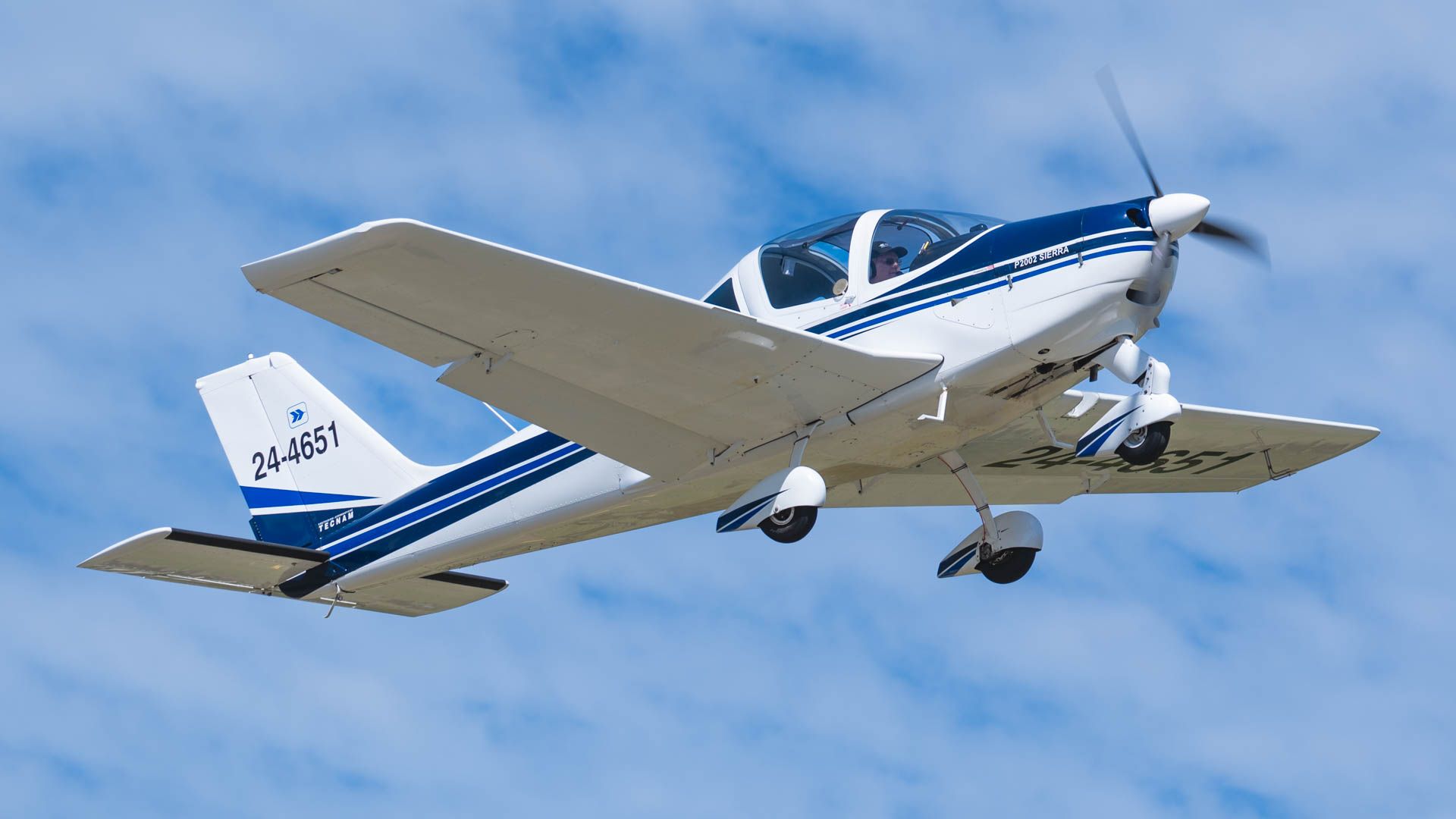 A small propeller plane is flying in the sky.