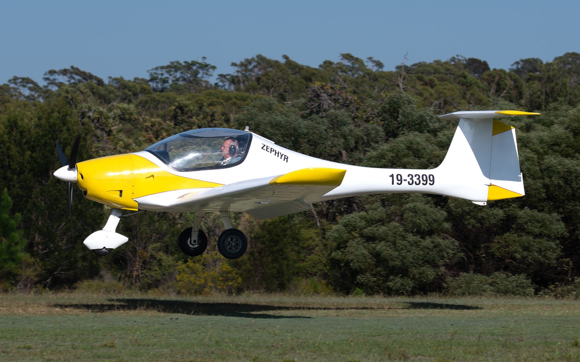 a yellow and white plane with the numbers 19-23566 on the tail