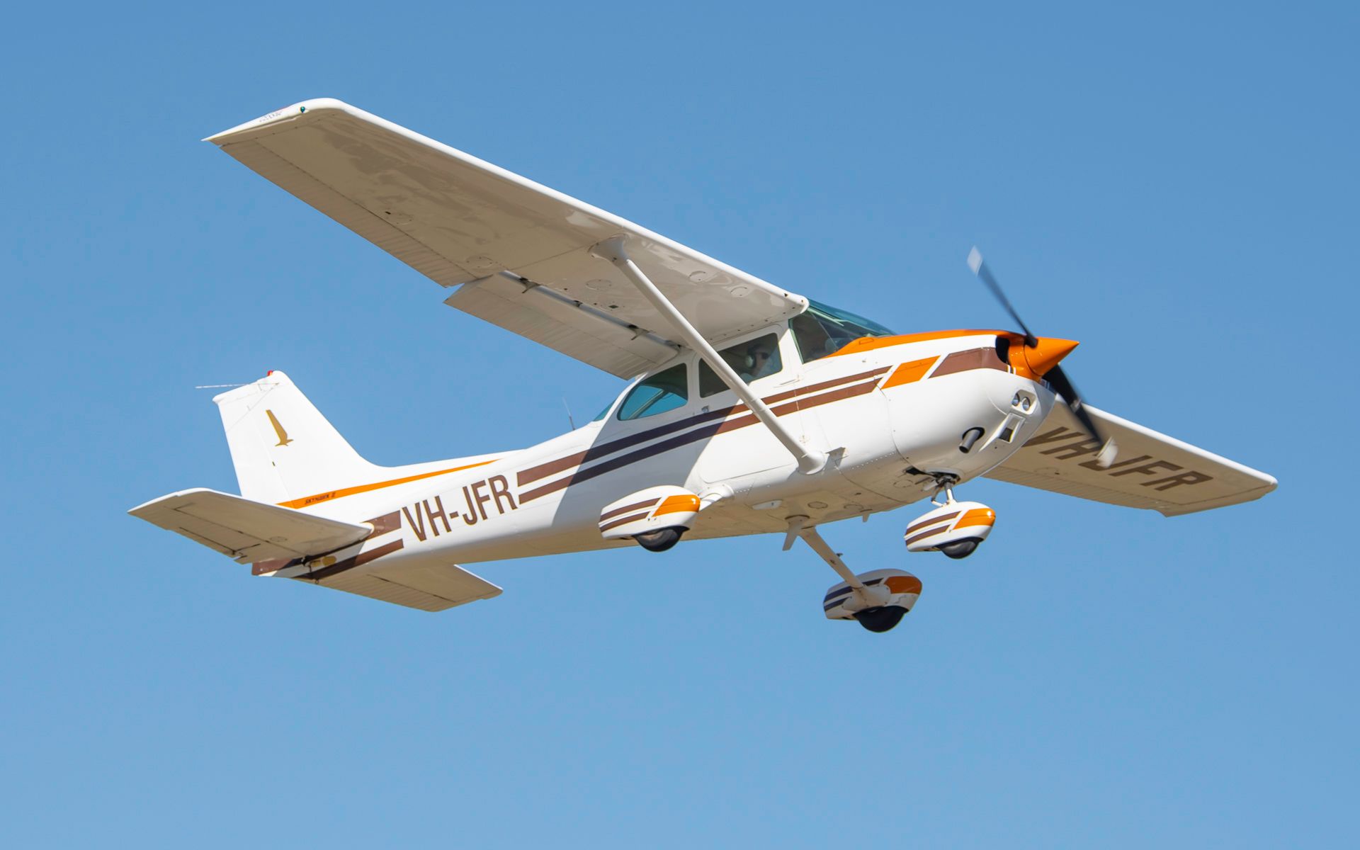 a small plane with the letters vw-jfr on the side is flying in the sky .