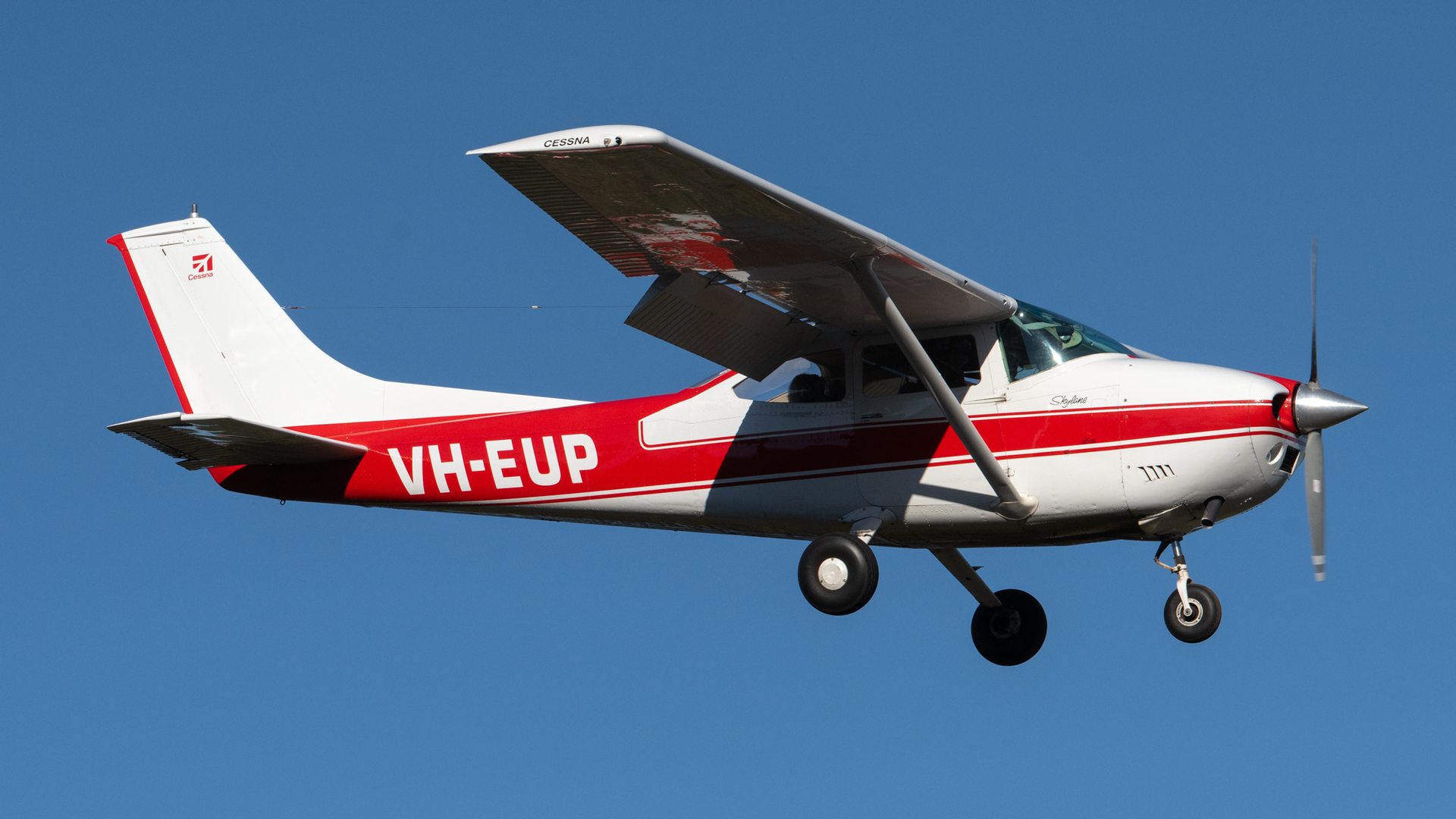 A small red and white plane with the letters vh-eup on it