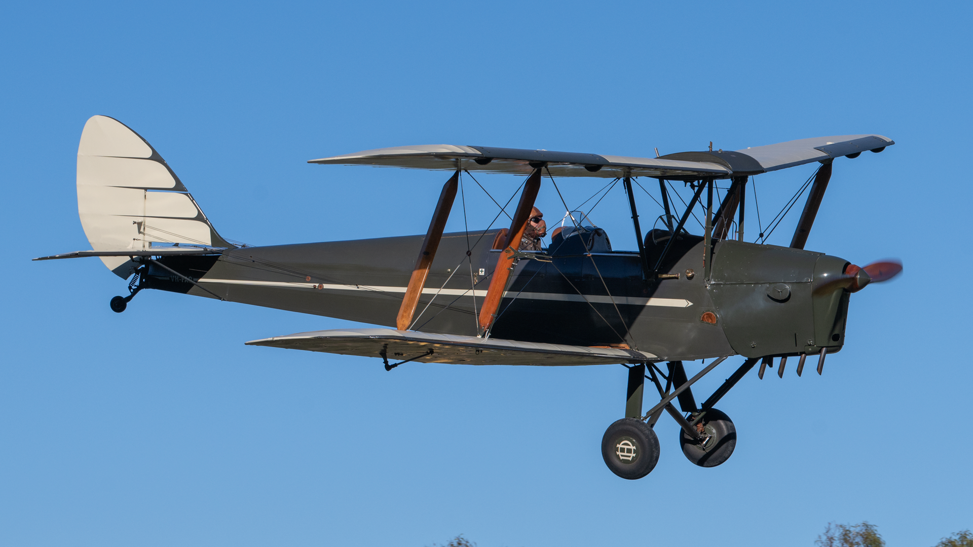 A small plane is flying in the sky with a blue sky in the background