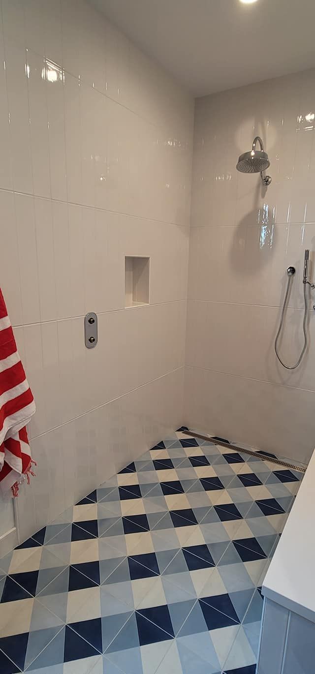 A bathroom with a shower and a checkered floor.