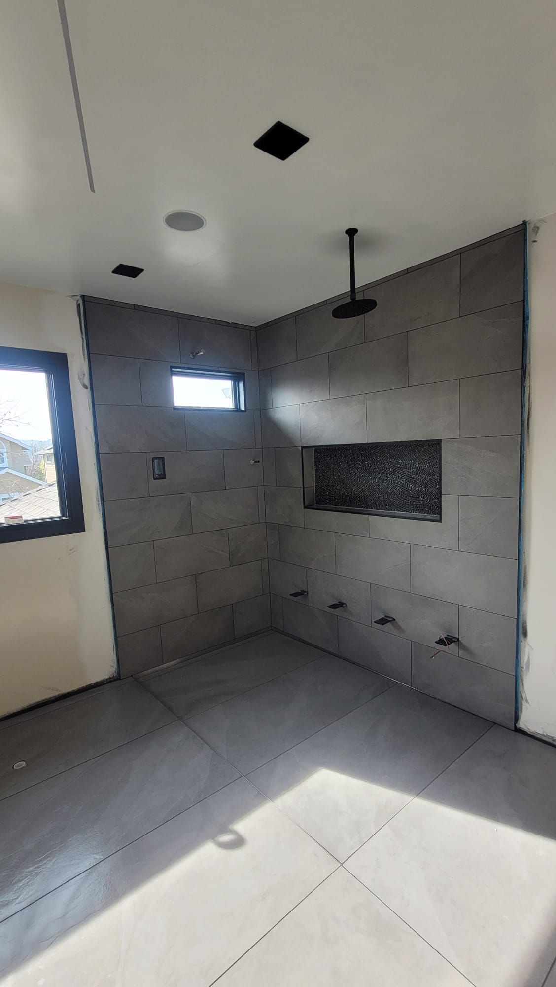 A bathroom under construction with a shower and a window.