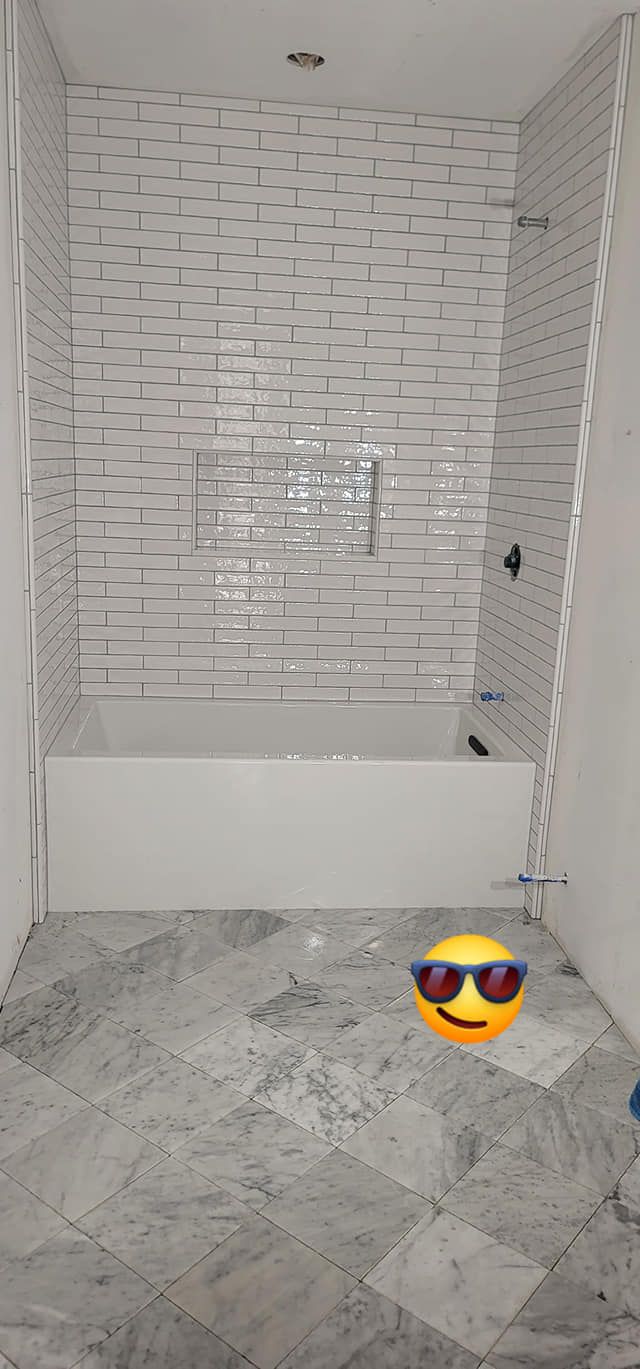 A bathroom with a bathtub and a smiley face on the floor.