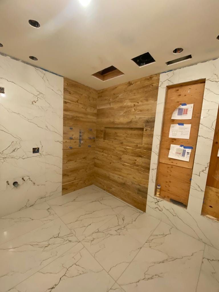 A bathroom under construction with wooden walls and tile floors.