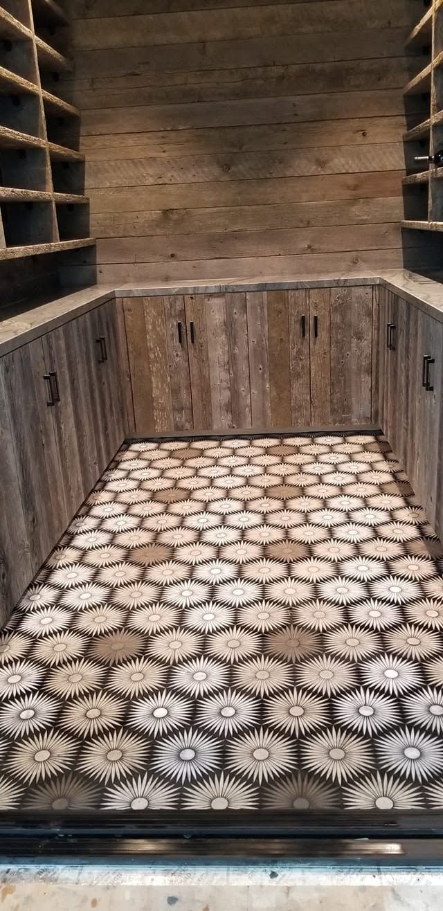 A room with a tiled floor and wooden cabinets.