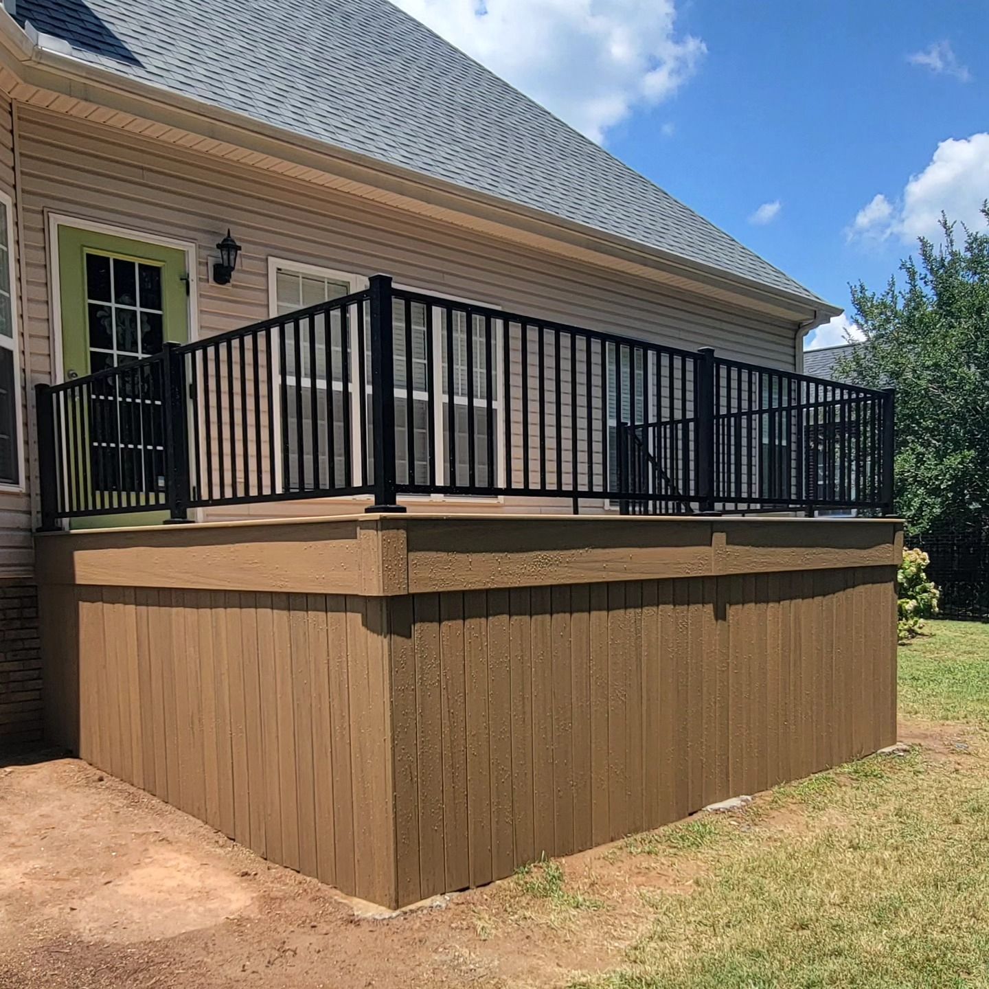 A gray home with a screened porch, deck, and stairs. White railing and trim, gray siding.