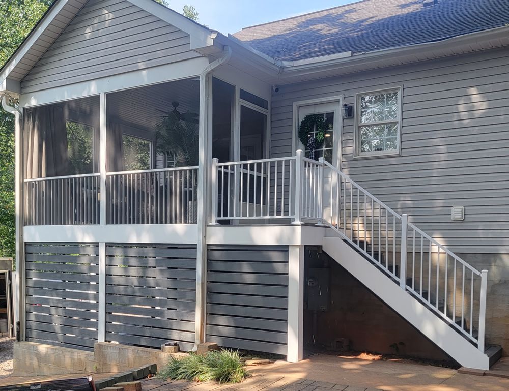 Grey and white deck with stairs, a screened porch, and a house exterior.