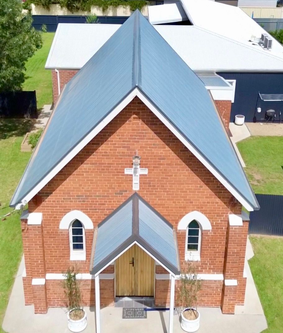 A red brick church with a metal a frame roof — Essential Roofing and Plumbing in Wagga Wagga, NSW