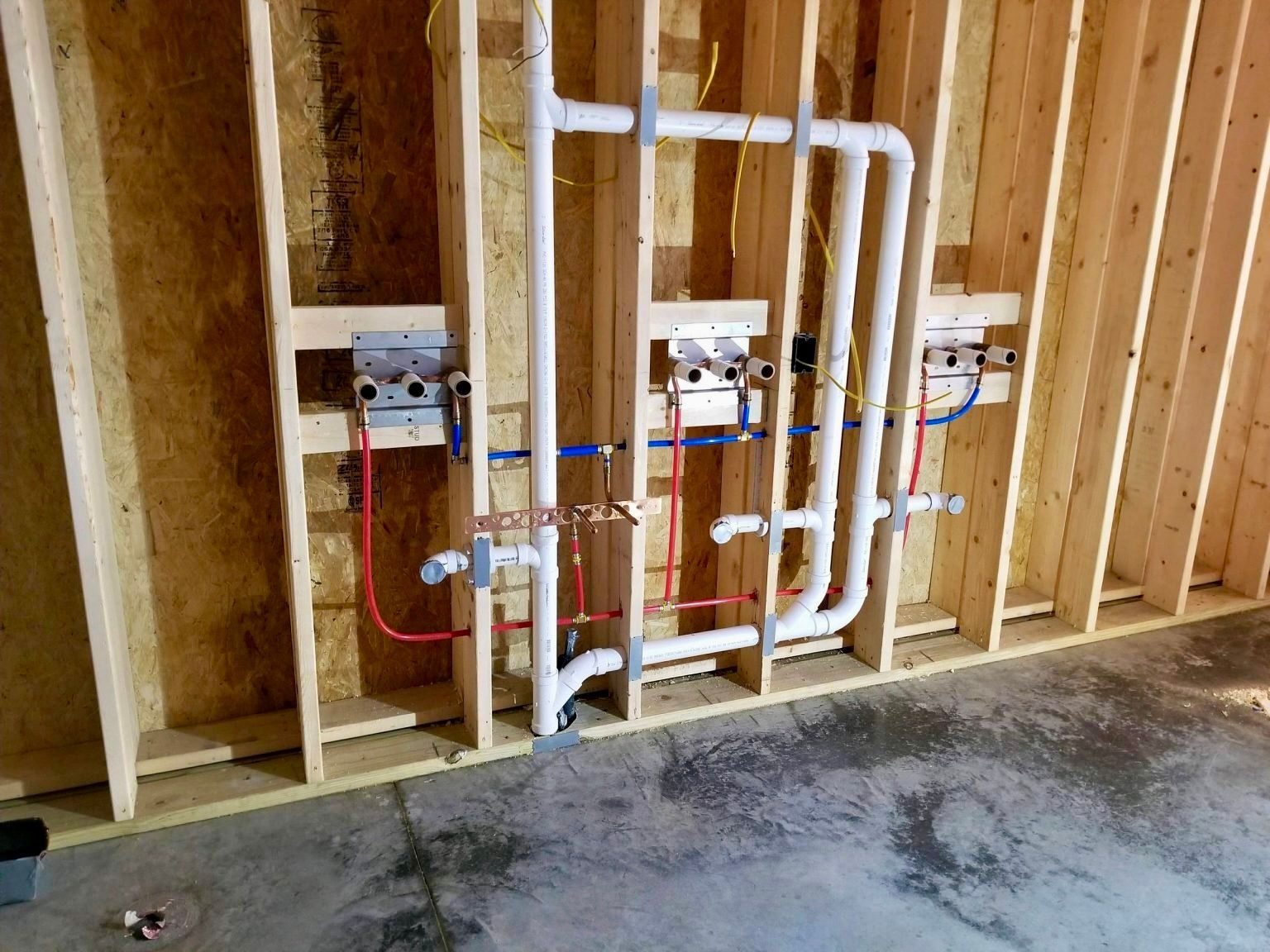 A Wall being build with plumbing pipes installed — Essential Roofing and Plumbing in Wagga Wagga, NSW